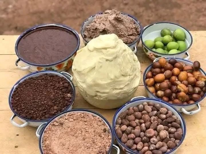 Matières premières du karité : noix, amandes, pâte broyée et beurre crémeux dans des bols émaillés